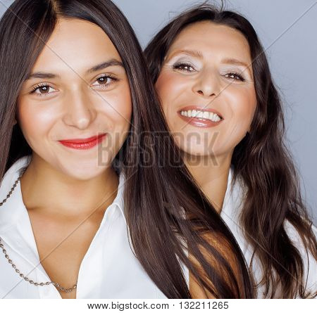 cute pretty teen daughter with mature mother hugging, fashion style brunette makeup close up, real happy family