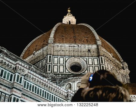 woman photographing the dome of Florence Cathedral at night