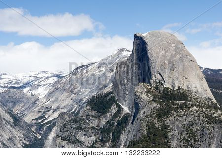 Majestic Half Dome against a cloudy, blue sky