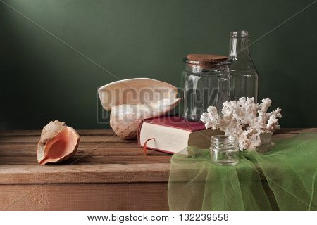 Still life with seashells and book on a wooden deck
