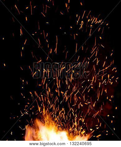 smithy fire flame tips with sparks closeup on dark background