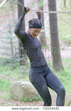 STOCKHOLM SWEDEN - MAY 14 2016: Woman with mud in her face trying to maintain her balance on a slack rope in the obstacle race Tough Viking Event in Sweden May 14 2016