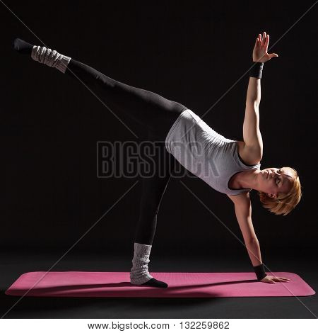 Young woman practicing yoga, Trikonasana / Bikram triangle left
