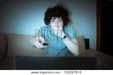 Young Scared Man Is Watching Horror Or Thriller On Tv And Holds