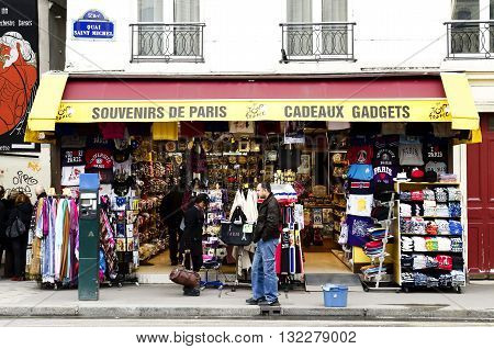 Paris France - March 19 2012: Souvenirs at the center of Paris near the cathedral of Notre Dame. Store is empty the seller expects the arrival of tourists. The tourist asks the price of a souvenir seller
