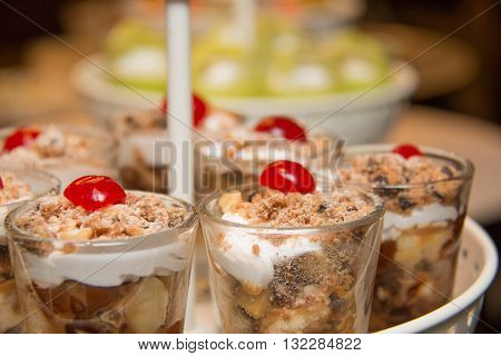 Banoffee pie in a mini glass spilled with caremel and whipped cream delicious dessert.