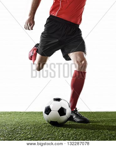 close up legs of football player in red socks and black shoes running and kicking the ball in free kick action playing isolated on white background