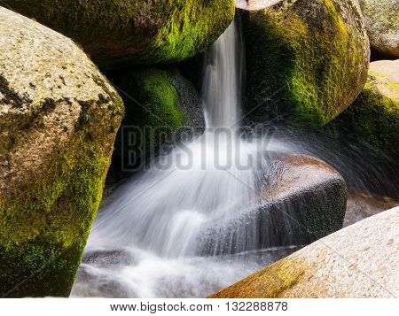Blurred river stream detail of wild rocky mountain river. Silky effect. Motion rendition effect. Slow shutter speed effect. Long exposure effect.