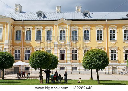 PILSRUNDALE, LATVIA - JULY 27, 2015: Unidentified people relax in front of the Rundale palace facade in Pilsrundale, Latvia.