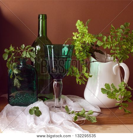 Still life with green glass and leaves