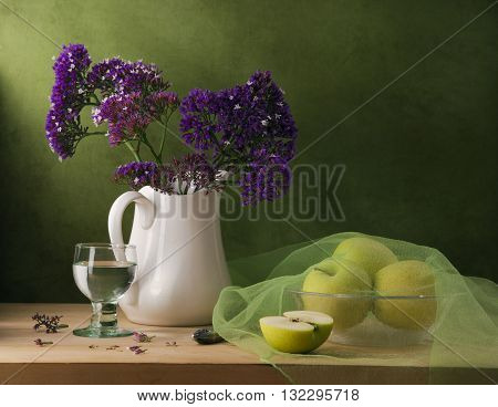 Still life with purple flowers and green apples