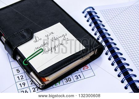Black leather note book with a slogan on a note pad with calendar