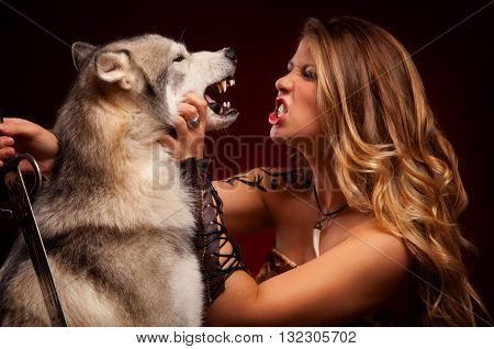 Warrior woman with husky. With sword and tatoo. Angry dog. Amazon girl.
