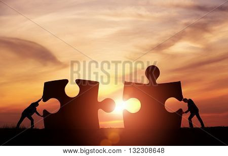 Teamwork concept. Two businessman connecting puzzle pieces togheter with copy space