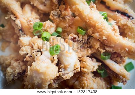 Plate of crispy calamari rings appetizer on green marble table