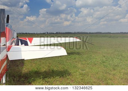 The aircraft is standing on the grass against the blue sky.
