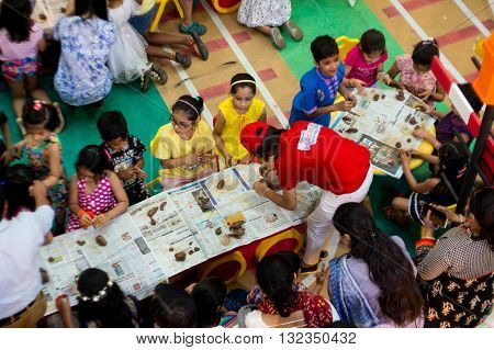 Delhi, India - 29th May 2016: Group of children being taught clay modelling by a teacher at a shopping mall in India. Summer classes are very popular to develop hobbies and art in the child