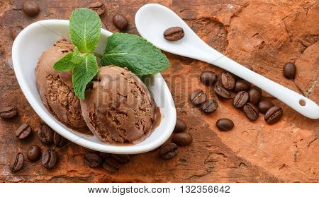 Coffee ice cream with mint leaves in a white Cup