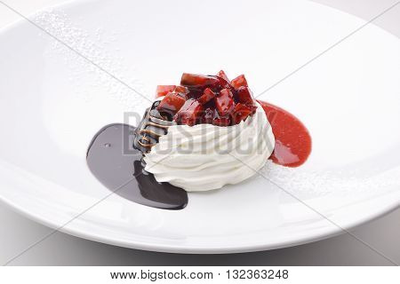 Dessert portion of whipped cream with chocolate cream and strawberries
