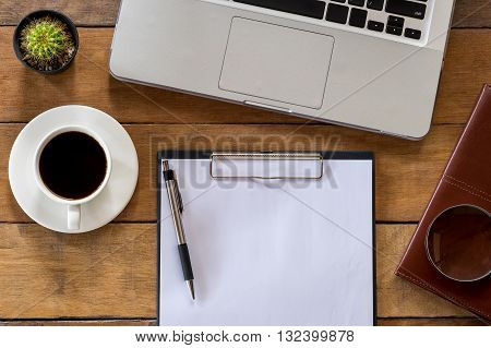 Office stuff with blank paper over blackboard pen leather notebook cup of coffee and labtop . Flat lay photo.Top view with copy space