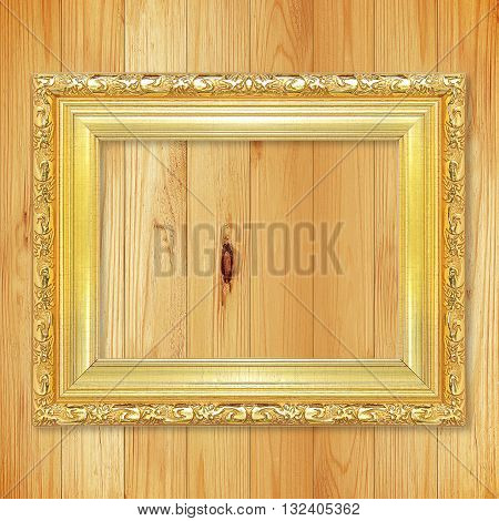 Antique gold frame on wooden wall;. Empty picture frame on wooden wall.