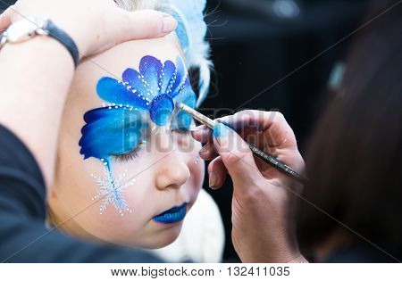 Christmas face painting, Portrait of little girl during the face painting session