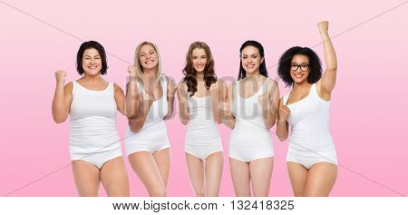 success, friendship, beauty, body positive and people concept - group of happy plus size women in white underwear celebrating victory over pink background