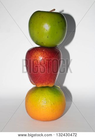 Vertical composition of three colorful fruits , isolated on white background