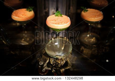 Colorfull orange and green cocktail with mint with reflection