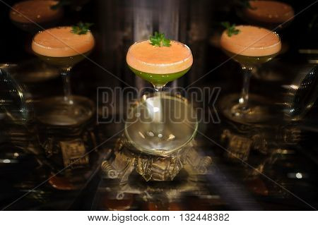 Colorfull orange and green cocktail with mint with reflection