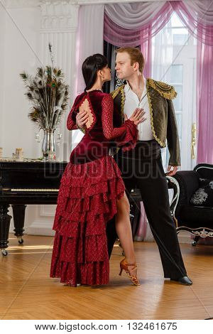 Dancing young couple in the room.
