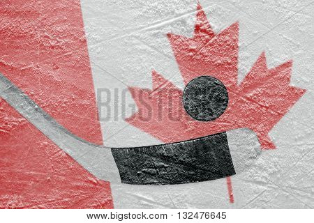 Hockey puck hockey stick and Canadian flag image on ice