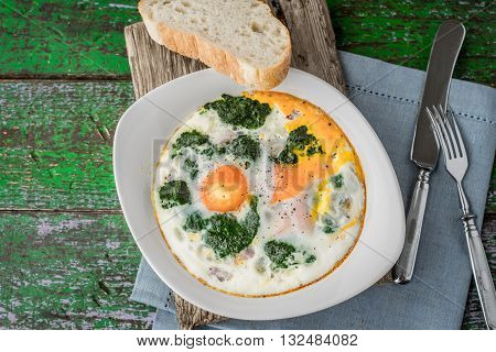 Florentine eggs with pureed spinach on the old wooden board