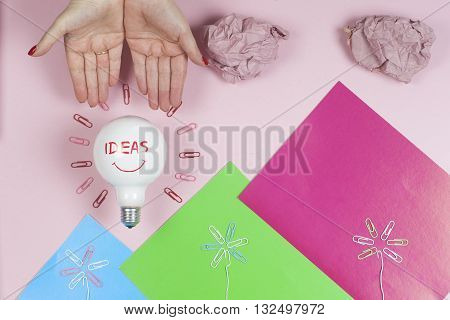 great idea concept with crumpled colorful paper and light bulb on light background. Creative brainstorm concept business idea. female hand holding light bulb. Copy space for text.