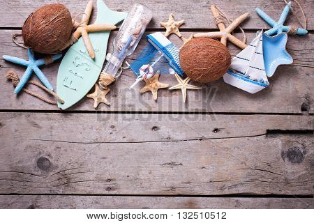 Border from coconuts and marine items on vintage wooden background. Sea objects on wooden planks. Selective focus. Flat lay. Vacation background. Place for text.