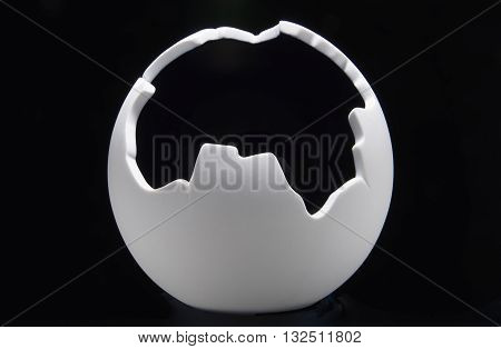 Broken white ball on a black background