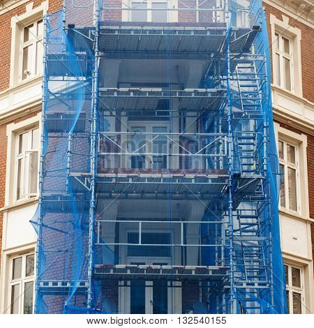 restoration facade of old house under blue net