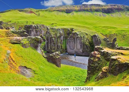  Enthusiastic woman - tourist on a rock canyon  Fjadrargljufur. Fantastic country Iceland