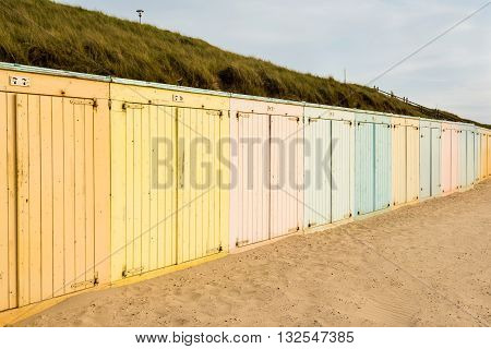 Lonely colorful beach lockers on a Dutch beach in sunset