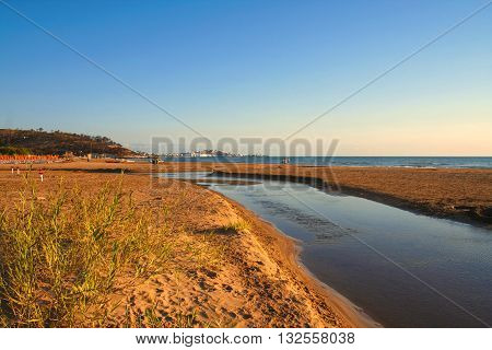 Summer seascape.Gargano coast: bay of Vieste.-(Apulia) ITALY-Portonuovo beach is a succession of fine sand dunes,crossed by many little kars streams,that cool the visitors in the hot summer time.