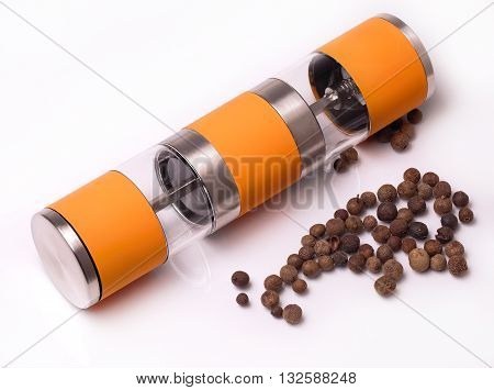 manual pepperbox and spilled pepper on the white background