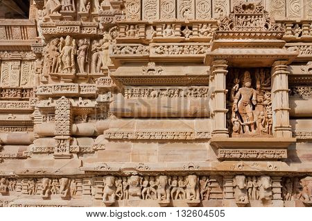 Brick wall with reliefs of Hindu temple of Khajuraho, India. UNESCO Heritage site built between 950 and 1150 in India belong to Hinduism and Jainism.