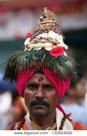 Pune India - July 11 2015: A portrait of a Vasudev pilgrims who are devotees of Lord Vishnu and wear a conical hat with peacock feathers. Vasudev has been a traditional since many years in Maharashtra. THese pilgrims go around singing praises of Lord Vish