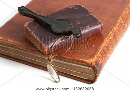 Antique two books and lorgnette from 19th century on white background