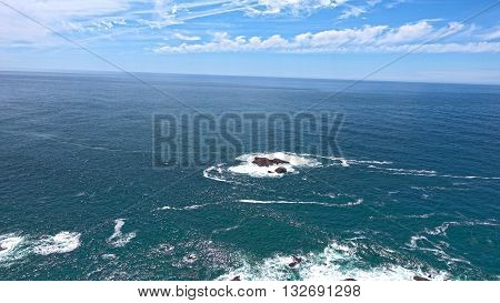 A small island.  Huge ocean in merging with the sky.