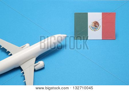 Trip by airplane to Malaysia. Miniature airplane flies toward the flag of Malaysia.