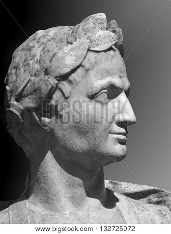 Gaius Julius Caesar sculpture on a gray background. 
Marble bust of  Roman general in the Summer Garden of Saint Petersburg.