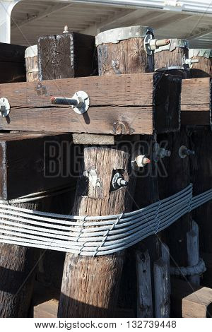 The metal hawser on the wooden post