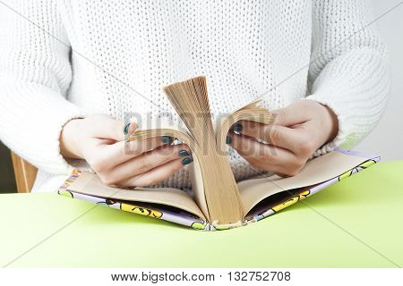 Young girl reading an open book old book. Knowledge Science. Back to school. Copy space. Toned image.