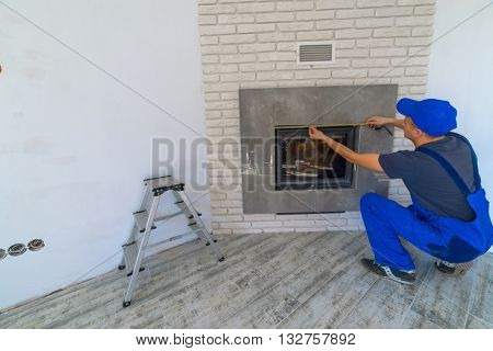 Fireplace installing in white brick wall